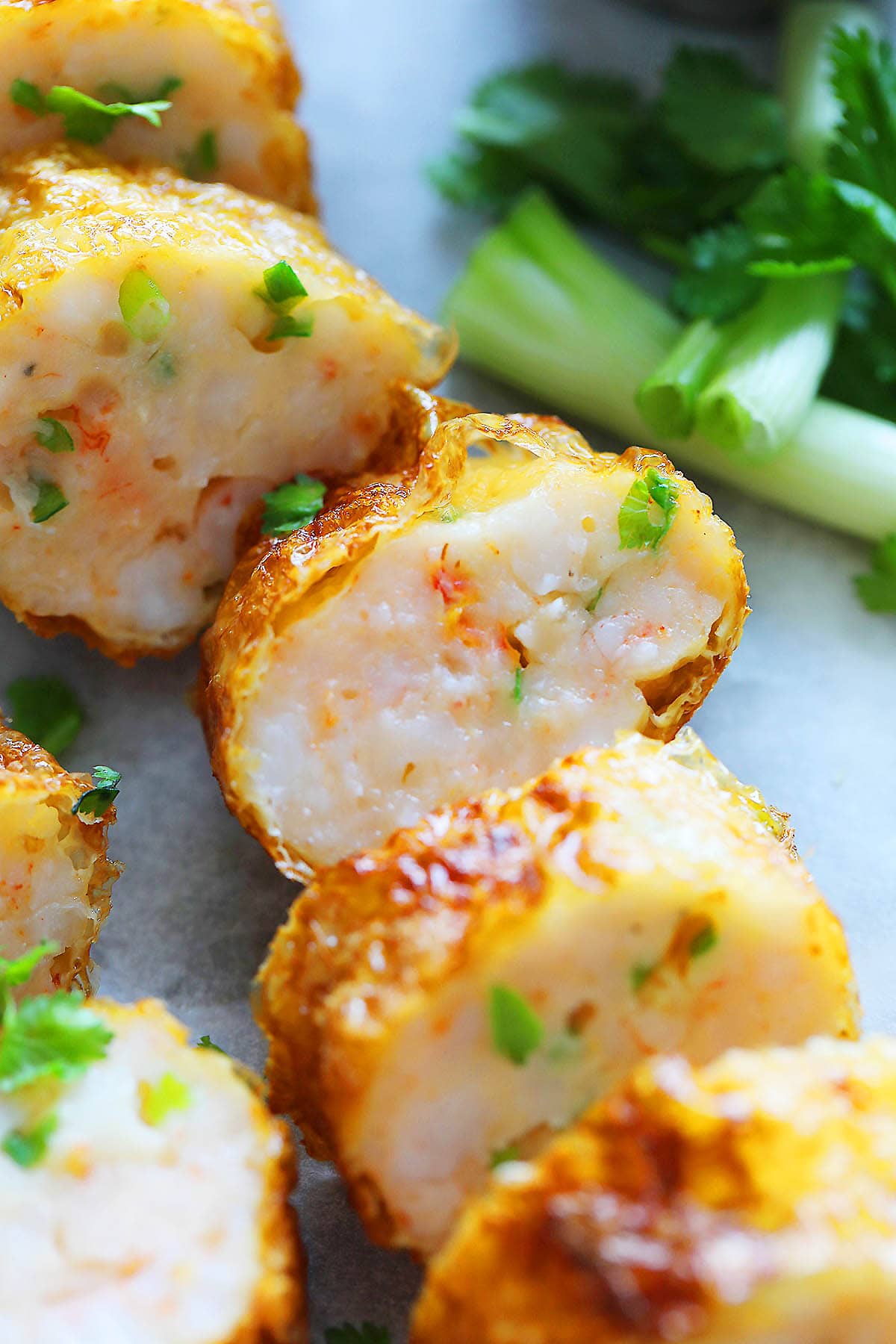 Pieces of deep fried bean curd shrimp roll on parchment paper.